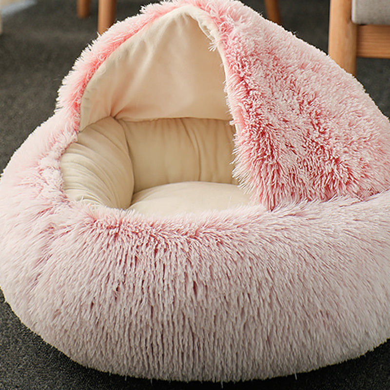 
Cat lying in a fluffy pink pet bed with a hand petting it