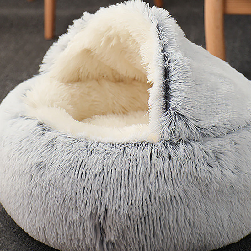 Gray fluffy pet bed with a white interior on a dark surface