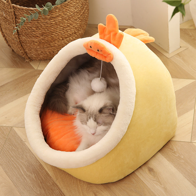 Cat lying in a yellow pet bed with orange accents on a wooden floor.