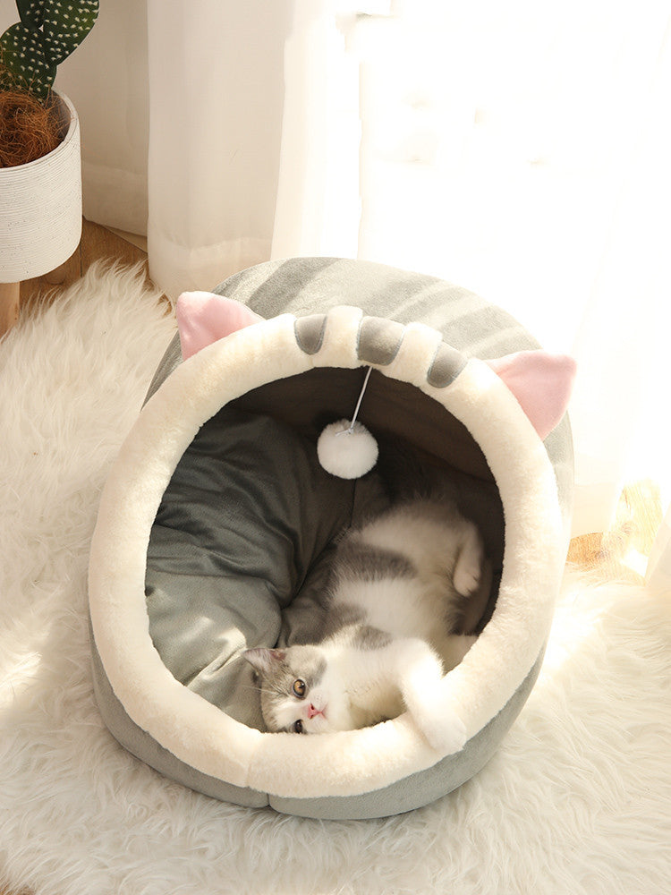 
Cat lying in a fluffy pink pet bed with a hand petting it