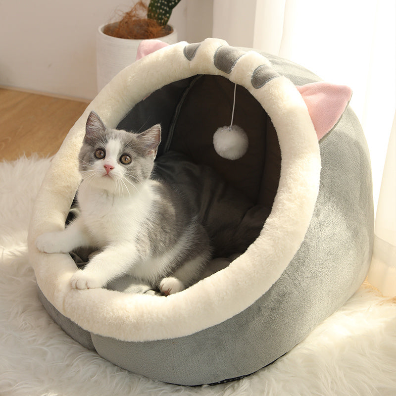 
Cat lying in a fluffy pink pet bed with a hand petting it