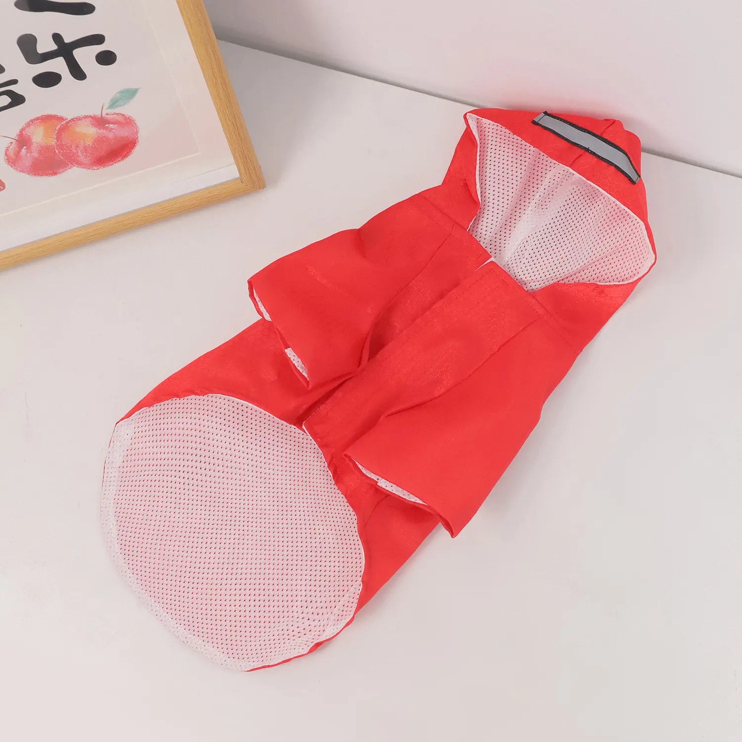 Red raincoat with mesh lining on a white surface