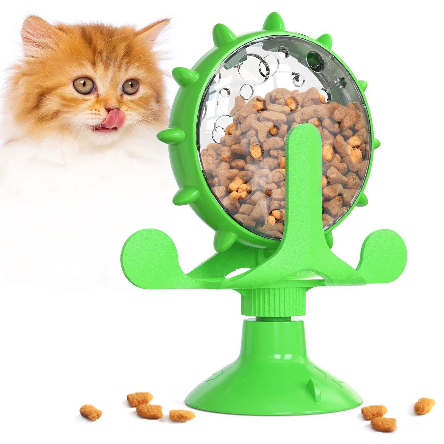 Green pet toy with a rotating wheel filled with cat food, next to a curious orange and white kitten.